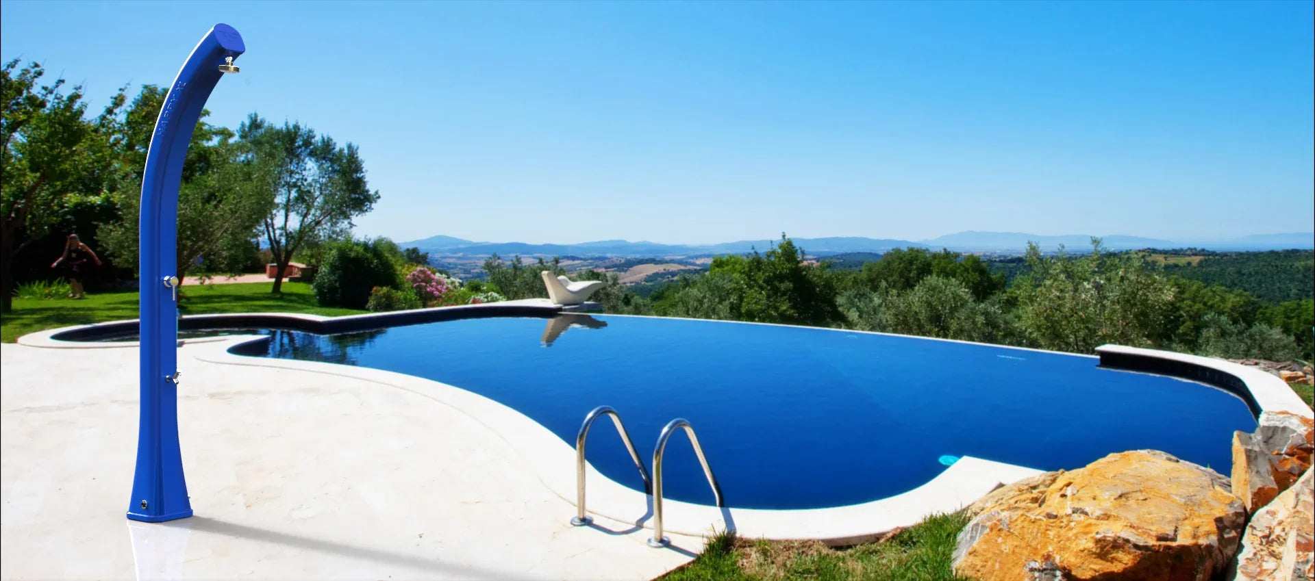 Doccia solare blu da esterno vicino a piscina panoramica in giardino con vista colline.