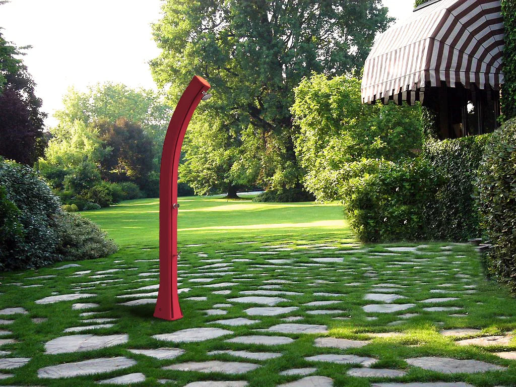 Doccia solare da giardino rossa su prato con vialetto in pietra, ideale per piscine.